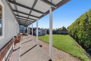 a pergola on the side of a house at Penguin Cottage in Tarakohe