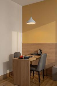 a kitchen with a wooden table and two chairs at Mai Living Apartment in Danang