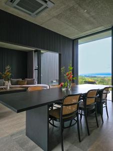a dining room with a large black table and chairs at KITOW private villa in Awaji