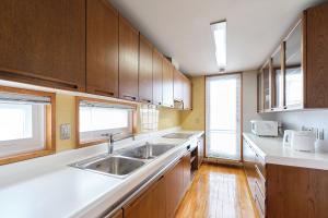 a kitchen with wooden cabinets and a sink at villa Jin Asahikawa in Asahikawa +56 photos
