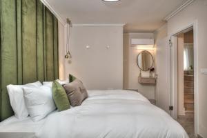 a bedroom with a white bed with a green headboard at סוויטות סוויט - Suite in Safed