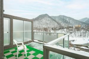 a balcony with a chair and a view of mountains at Fewdays Condominium301 in Sapporo