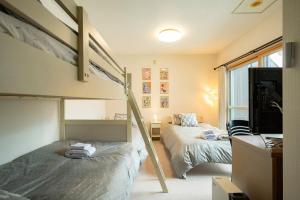 a bedroom with two bunk beds and a tv at Fewdays Condominium301 in Sapporo +59 photos