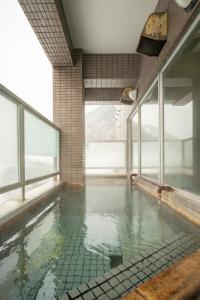a swimming pool in a building with glass windows at Fewdays Condominium301 in Sapporo