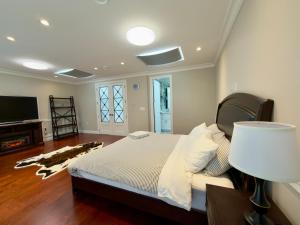 a bedroom with a bed with a lamp and a tv at 嘉博旅馆 Jiabo Hotel in Richmond