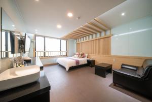 a bedroom with a bed and a bathroom with a sink at Nampo MGM Hotel in Busan