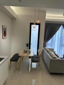 a living room with a table and a couch at seroja hills condominium in Sepang