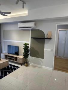a living room with a tv and a potted plant at seroja hills condominium in Sepang