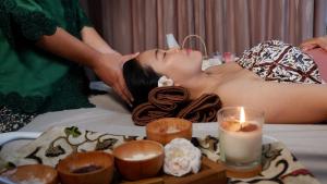 a woman getting a massage in a bath tub at Hortus Inn in Tawangmangu