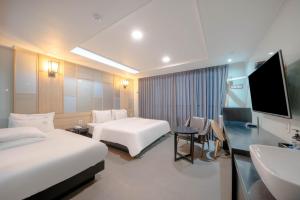a hotel room with two beds and a sink at Nampo MGM Hotel in Busan