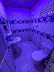 a bathroom with a toilet and a sink with a purple light at Anu Villa Wadduwa in Wadduwa +18 photos