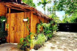 a wooden building with plants in front of it at MJs Garden Hotel Moalboal powered by Cocotel in Moalboal