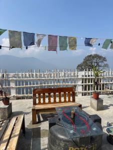 a bench and a table and a tire and a fence at Blue Valley Escape in Darjeeling