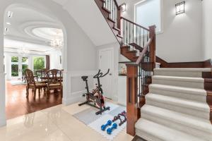 a home gym with a treadmill next to a staircase at 嘉博旅馆 Jiabo Hotel in Richmond