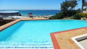 une grande piscine avec l'océan en arrière-plan dans l'établissement Chapman Hotel and Conference Centre, à Port Elizabeth