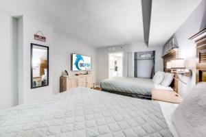 a large bedroom with a bed and a mirror at Oceanfront condo Heated Pools & Breathtaking View! in Myrtle Beach