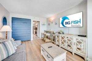 a living room with a big fish rentals sign on the wall at Oceanfront condo Heated Pools & Breathtaking View! in Myrtle Beach