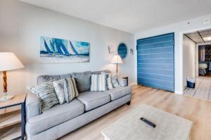 a living room with a couch and a blue garage door at Oceanfront condo Heated Pools & Breathtaking View! in Myrtle Beach
