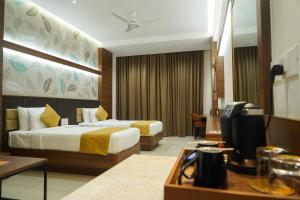 a hotel room with two beds and a television at Highland Hotel in Bangalore +70 photos