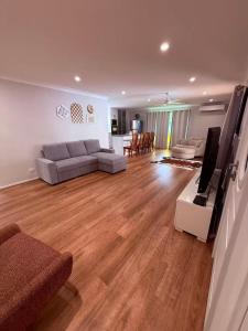 a living room with a couch and a flat screen tv at Charming Riverside Retreat sleep6 in Dora Creek