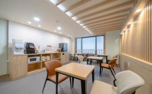 a room with tables and chairs and a kitchen at Nampo MGM Hotel in Busan