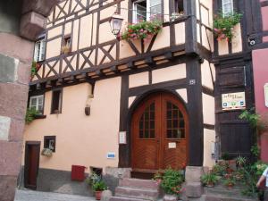 un edificio antiguo con una puerta de madera y escaleras en Vintage Apartment in Riquewihr with Terrace en Riquewihr