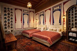 a bedroom with a large bed with red sheets and blue and white walls at Chorminor 1 min to Bukhara Old Town GET EARLY CHECK IN AND LATE CHECK OUT in Bukhara +40 photos