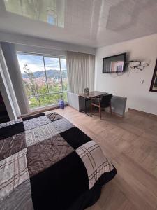 a bedroom with a bed and a desk and a window at Cabaña Belvedere in Duitama