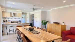 a kitchen and dining room with a wooden table and chairs at Marignano Homestead in Broke