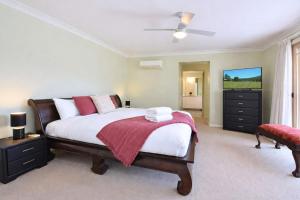 a bedroom with a large bed with a red blanket at Marignano Homestead in Broke