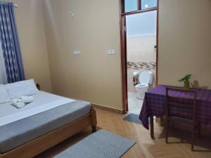 a bedroom with a bed and a toilet and a window at Shilling Stays in Msaranga