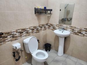 a bathroom with a toilet and a sink at Shilling Stays in Msaranga