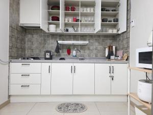 a kitchen with white cabinets and a sink at 스테이일룸 in Sŭngch'ŏn-ni