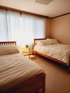 a bedroom with two beds and a window at 스테이일룸 in Sŭngch'ŏn-ni