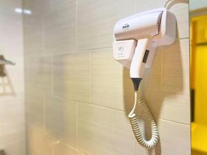 a phone is hanging on a wall in a bathroom at Seeds Hotel Shah Alam Seksyen 7 I-City in Shah Alam