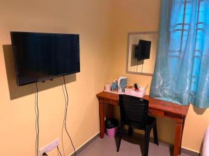 a desk with a television and a desk with a chair at Kemas Homestay in Johor Bahru
