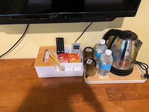 a tray with a tea kettle and drinks on a table at Kemas Homestay in Johor Bahru