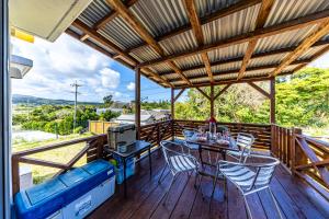 a porch with a table and chairs and a couch at Unbi Stay in Nakijin