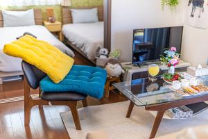 a living room with a chair and a table at Unbi Stay in Nakijin