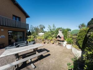 a wooden picnic table sitting outside of a building at Quaint Holiday Home In Girmont Val d Ajol with Terrace in Girmont-Val-dʼAjol