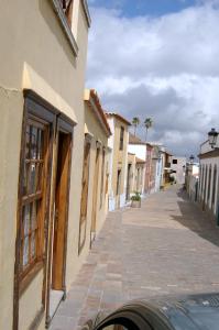 una calle en una ciudad con edificios y un coche en Casa Rural El Traspatio, en Granadilla de Abona
