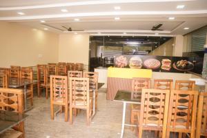 a dining room with tables and chairs in a restaurant at Hotel Koyla Boarding and Lodging in Chikmagalūr
