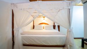 a bedroom with a canopy bed with white curtains at La Roche Hotel Sigiriya in Sigiriya +74 photos