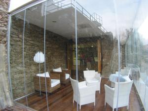 a room with white chairs and a stone wall at Quinta dos Castanheiros - Turismo Rural in Negreda