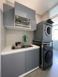 a kitchen with a sink and a washing machine at Kacy Homestay, Wonderland Hồ Tràm miễn phí vé MUSEUM in Xuyên Mộc