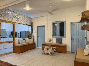 a living room with two benches and a table at Thulusdhoo Garden Villa in Thulusdhoo