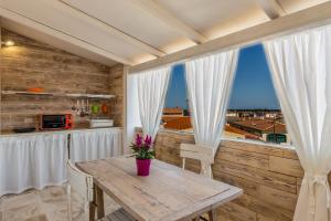 jadalnia ze stołem i dużym oknem w obiekcie Mannois - Lofts & Apartments w mieście Orosei