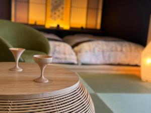 a wooden table with two wine glasses on top of it at Hokkaido Zen Cabin in Bibai