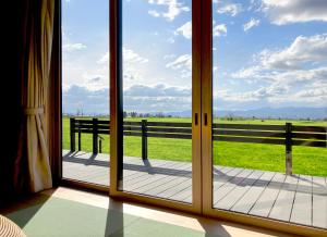 a sliding glass door with a view of a field at Hokkaido Zen Cabin in Bibai