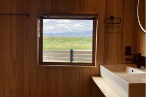 a bathroom with a window with a view of a field at Hokkaido Zen Cabin in Bibai
